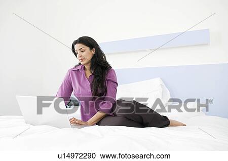 Businesswoman working in her bedroom View Large Photo Image Stock Image - Businesswoman working in her bedroom. Fotosearch