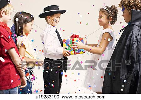 Stock Image - child handing over present in party. Fotosearch