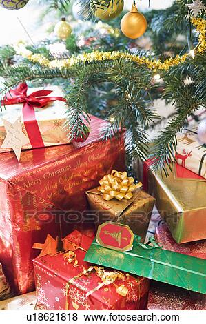 Stock Photo - Christmas presents under decorated tree. Fotosearch