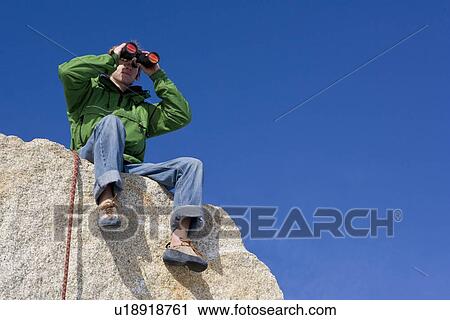 Climber looking through binoculars View Large Photo Image Stock Image - Climber looking through binoculars. Fotosearch