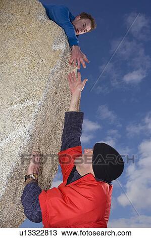 Climber offering hand to fellow climber View Large Photo Image Stock Image - Climber offering hand to fellow climber. Fotosearch