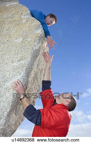 Climber offering hand to fellow climber View Large Photo Image Stock Photo - Climber offering hand to fellow climber. Fotosearch