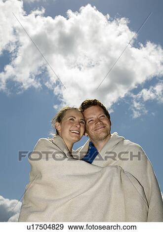 Couple Huddled in Blanket View Large Photo Image Stock Photo - Couple Huddled in Blanket. Fotosearch