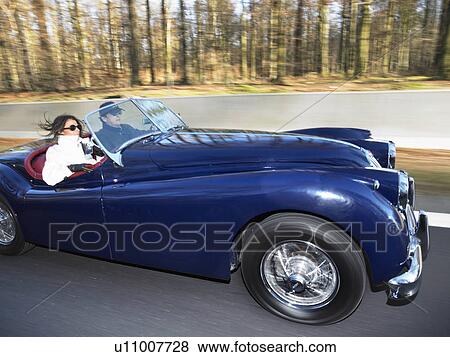 Couple in an old convertible, freeway View Large Photo Image Stock Photo - Couple in an old convertible, freeway. Fotosearch