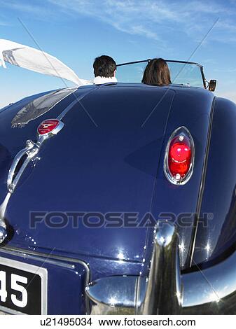 Couple in an old convertible View Large Photo Image Picture - Couple in an old convertible. Fotosearch