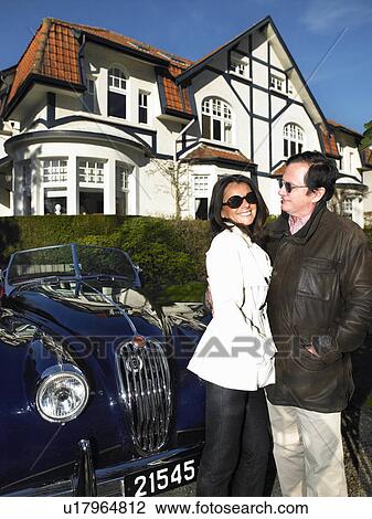Couple in front of their house and car View Large Photo Image Stock Image - Couple in front of their house and car. Fotosearch