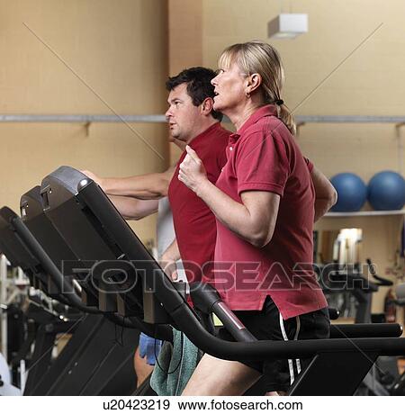 couple on running machines at gym View Large Photo Image Stock Photo - couple on running machines at gym. Fotosearch