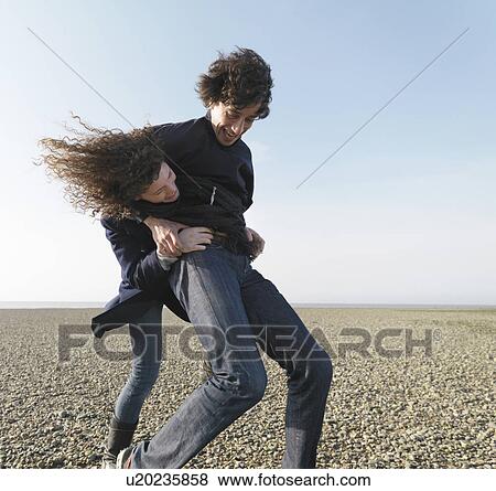 Couple playing on beach View Large Photo Image Stock Photo - Couple playing on beach. Fotosearch