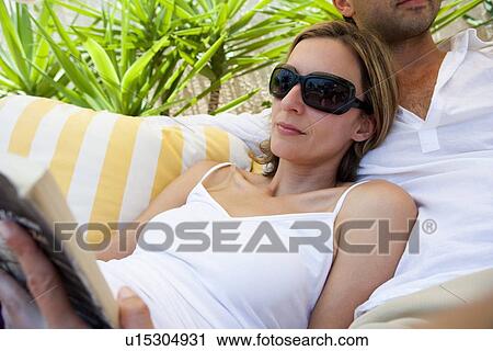 Stock Image - Couple Relaxing On Sunbed. Fotosearch