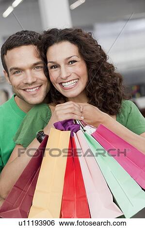 couple shopping holding up shopping bags View Large Photo Image Stock Photograph - couple shopping holding up shopping bags. Fotosearch