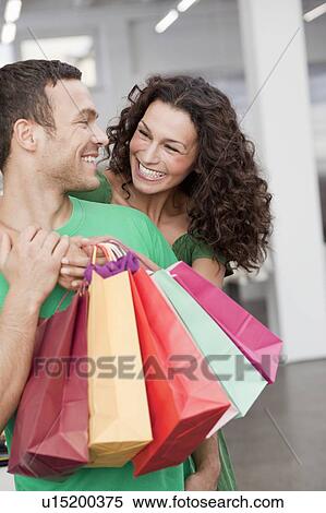 couple shopping holding up shopping bags View Large Photo Image Stock Photography - couple shopping holding up shopping bags. Fotosearch