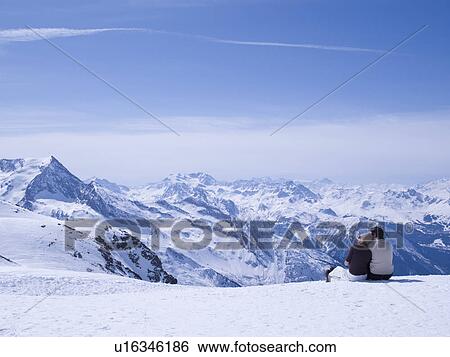 couple sitting in the snow hugging View Large Photo Image Stock Photograph - couple sitting in the snow hugging. Fotosearch