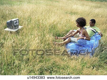 Couple watching television outside View Large Photo Image Stock Image - Couple watching television outside. Fotosearch
