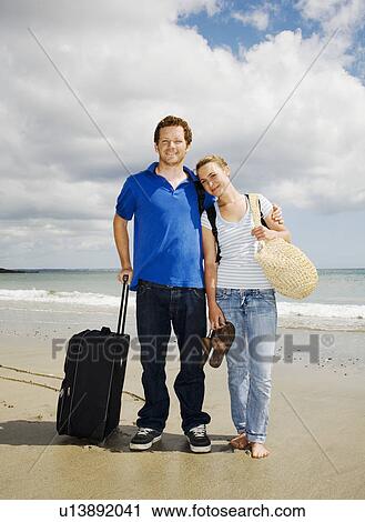 Couple with case on beach View Large Photo Image Stock Image - Couple with case on beach. Fotosearch