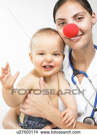 Doctor carrying baby boy View Large Photo Image Picture - Doctor carrying baby boy. Fotosearch