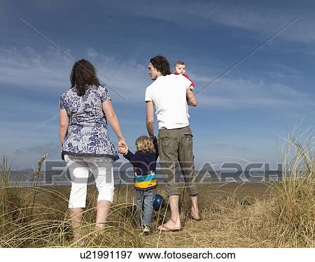 Stock Photo - family at beach looking out to sea. Fotosearch