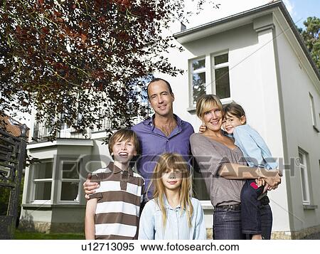 Stock Photography - Family standing in front of their house. Fotosearch