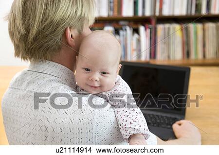 father working on laptop carrying baby View Large Photo Image Picture - father working on laptop carrying baby. Fotosearch