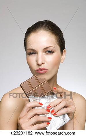 Stock Image - Female beauty model eating chocolate. Fotosearch