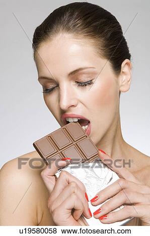 Female beauty model eating chocolate View Large Photo Image Stock Photo - Female beauty model eating chocolate. Fotosearch