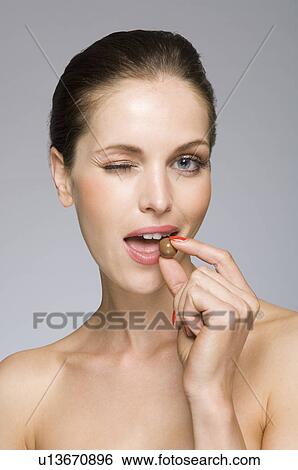 Stock Photograph - Female beauty model eating chocolate. Fotosearch
