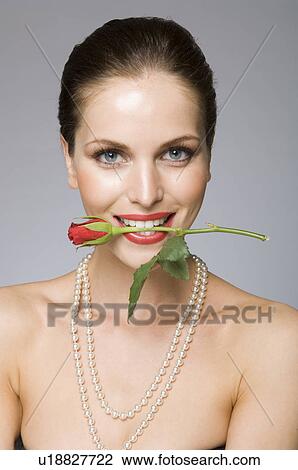 Stock Image - Female beauty model rose in mouth. Fotosearch
