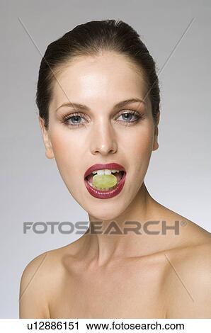 Stock Image - female beauty with grape in mouth. Fotosearch