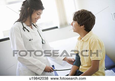 Female Doctor examining boy patient View Large Photo Image Stock Photo - Female Doctor examining boy patient. Fotosearch