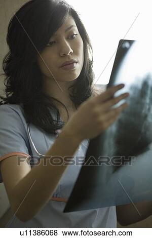 Female Doctor looking at x-ray View Large Photo Image Stock Photo - Female Doctor looking at x-ray. Fotosearch