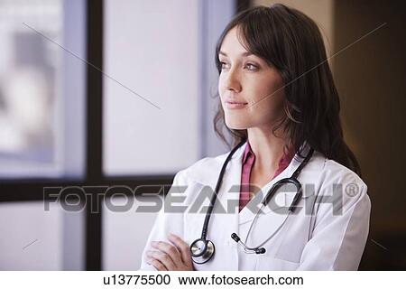 Female Doctor looking out window View Large Photo Image Stock Image - Female Doctor looking out window. Fotosearch