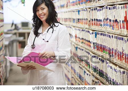 Female Doctor with medical file smiling View Large Photo Image Stock Image - Female Doctor with medical file smiling. Fotosearch