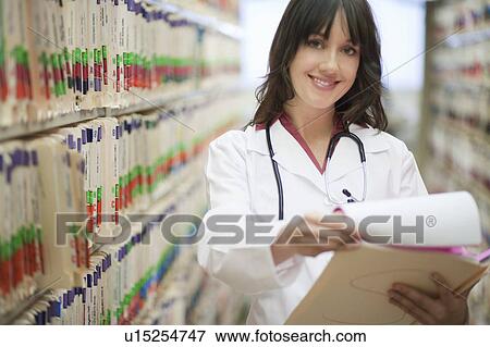 Female Doctor with medical file smiling View Large Photo Image Stock Photo - Female Doctor with medical file smiling. Fotosearch