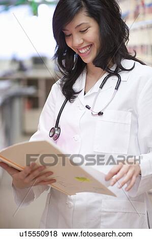 Stock Photo - Female Doctor with medical file smiling. Fotosearch