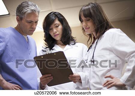 Female Doctors and surgeon reading file View Large Photo Image Stock Photograph - Female Doctors and surgeon reading file. Fotosearch