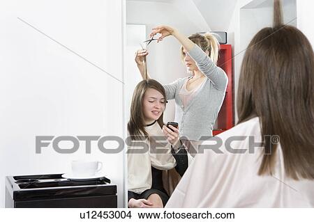 Female talking on phone at hairdressers View Large Photo Image Picture - Female talking on phone at hairdressers. Fotosearch