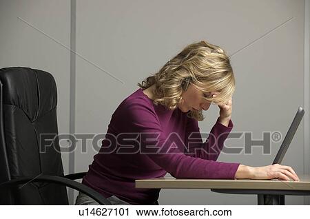 Stock Image - female worker at desk. Fotosearch