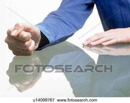 Stock Photo - Fist of a woman on table. Fotosearch