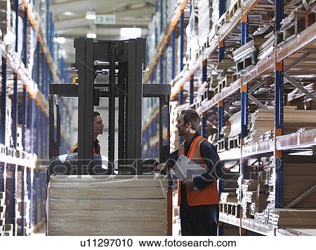 Stock Image - Forklift And Workers In Warehouse. Fotosearch