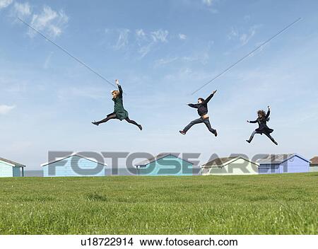 Friends jumping across roofs by seaside View Large Photo Image Picture - Friends jumping across roofs by seaside. Fotosearch