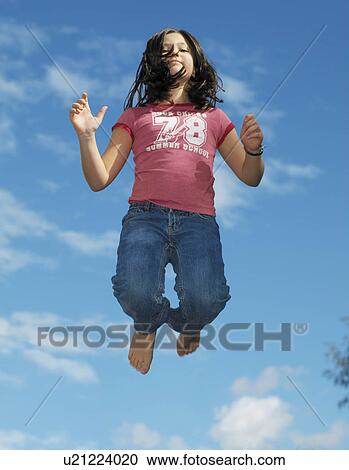 Stock Image - Girl, 10 jumping on trampoline. Fotosearch