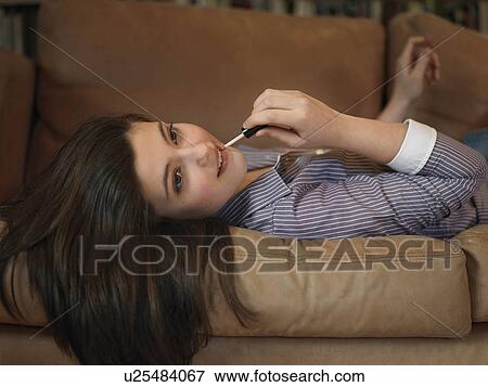 Girl, 14 applying lip gloss View Large Photo Image Stock Photo - Girl, 14 applying lip gloss. Fotosearch