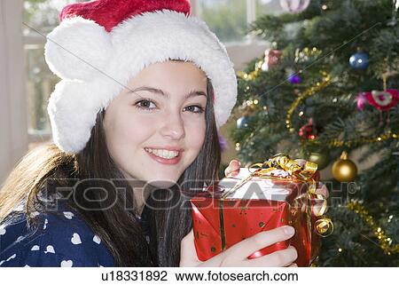 Girl, 14 holding Christmas present View Large Photo Image Stock Image - Girl, 14 holding Christmas present. Fotosearch