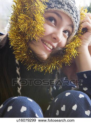 Girl, 14 holding Christmas tinsel View Large Photo Image Stock Photo - Girl, 14 holding Christmas tinsel. Fotosearch