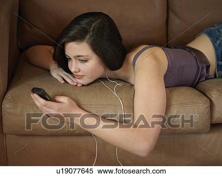 Girl, 14 listening to music on mobile View Large Photo Image Stock Photography - Girl, 14 listening to music on mobile. Fotosearch