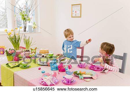 girl and boy admire easter table View Large Photo Image Stock Photography - girl and boy admire easter table. Fotosearch