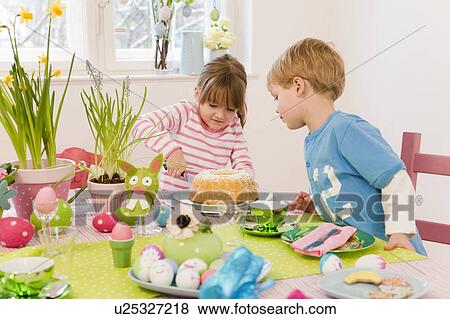girl and boy cutting cake easter table View Large Photo Image Stock Photo - girl and boy cutting cake easter table. Fotosearch