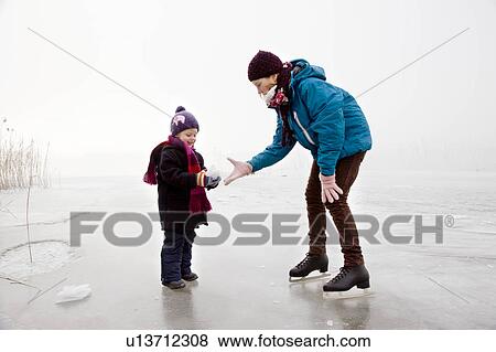 Girl and boy iceskating on frozen lake View Large Photo Image Stock Photo - Girl and boy iceskating on frozen lake. Fotosearch