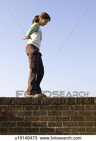 Girl balancing on wall View Large Photo Image Stock Image - Girl balancing on wall. Fotosearch