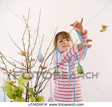 Picture - girl decorating twigs for easter. Fotosearch