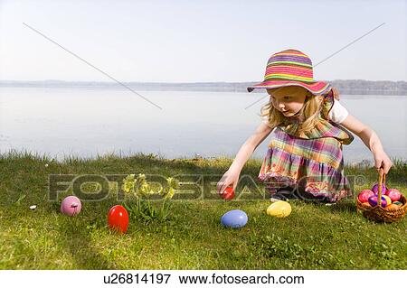 Stock Photo - girl finding easter eggs. Fotosearch